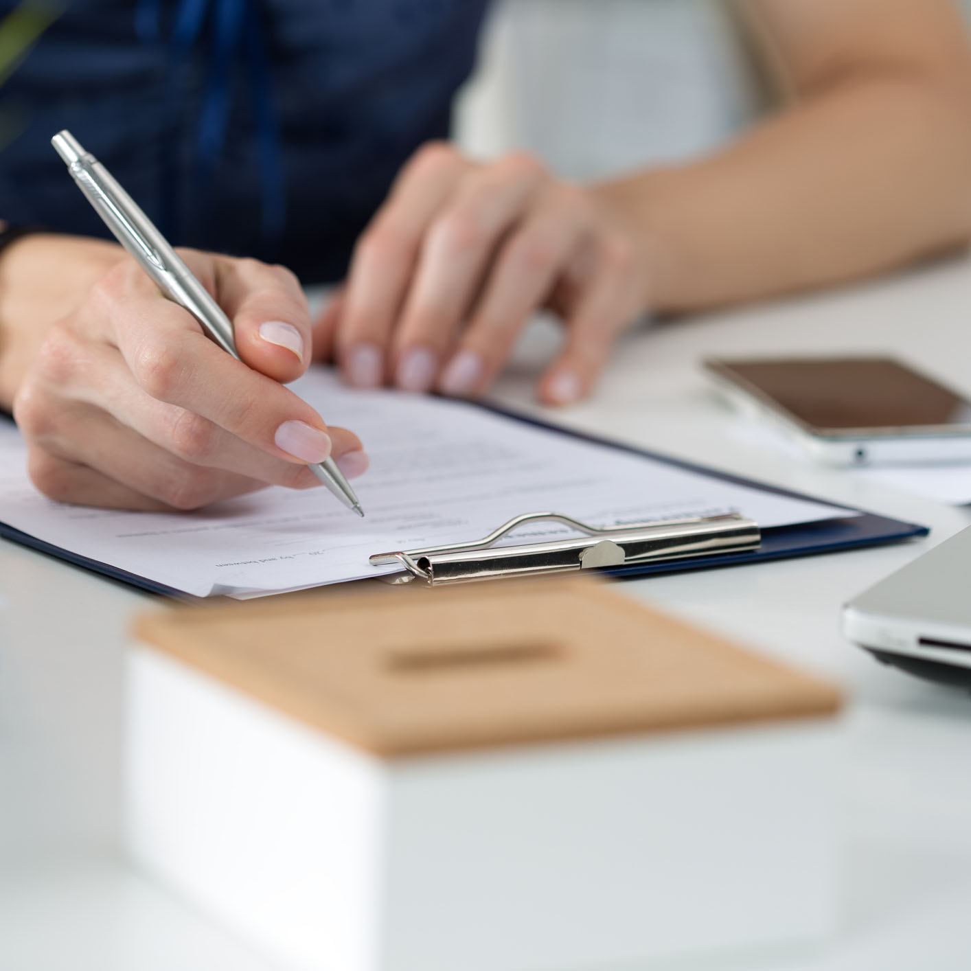 Person filling out form attaced to a clipboard