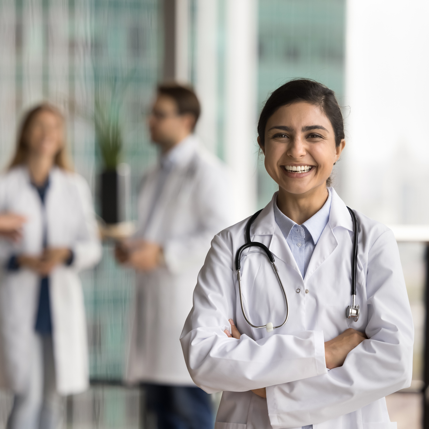 physician smiling in front of other physicians